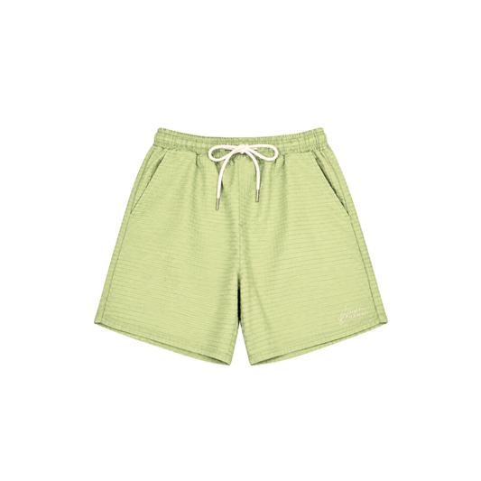 Light green textured drawstring shorts with a white drawstring and a small white script logo on the lower left leg, shown flat on a white background.