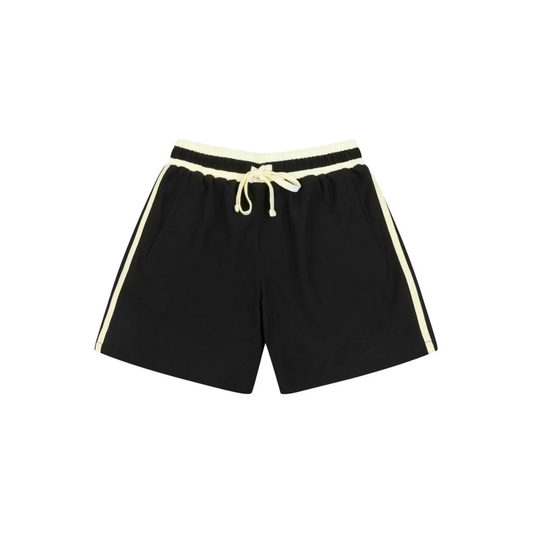 Black athletic shorts with cream-colored side stripes, a cream elastic waistband, and a cream drawstring, shown flat on a white background.